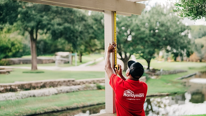 Mr. Handyman technician measuring a pergola.