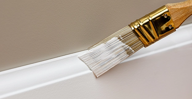 Painting moulding with brush.
