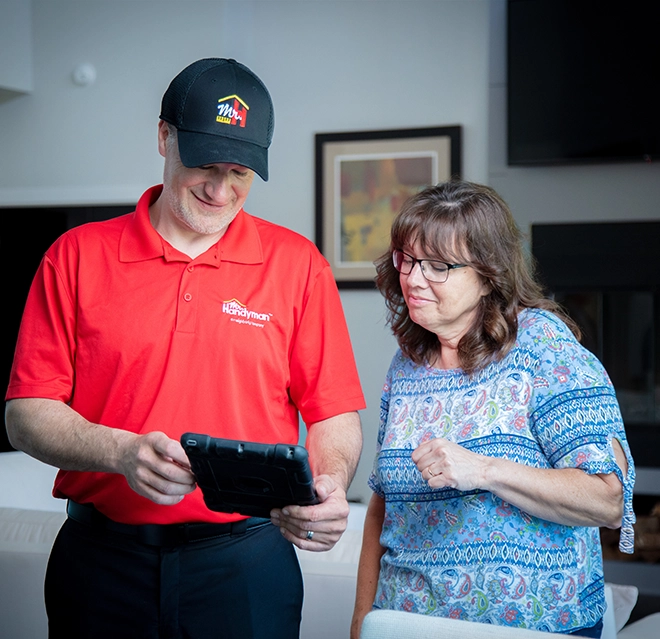 Mr. Handyman professional showing customer tablet.