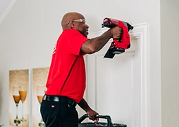 Mr. Handyman adding wood trimdoor frame to a door.