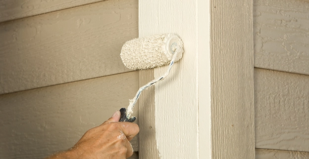 MRH Employee painting a wooden surface with a brush.