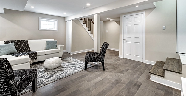 Modern basement living area featuring a white couch.