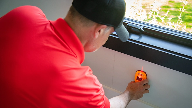 MRH employee scanning wall with stud finder.