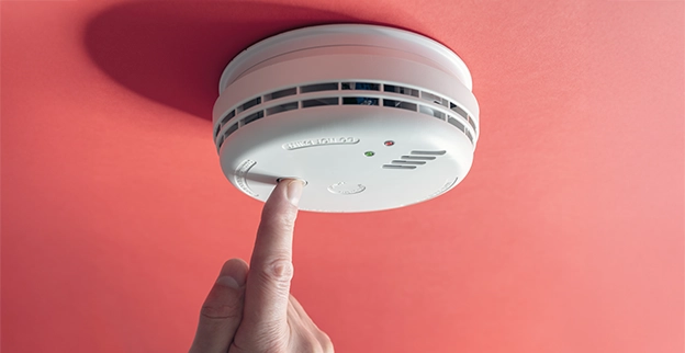 Smoke detector mounted on a red ceiling.