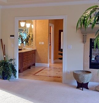 View from a living room into a bright bathroom with a wooden vanity.