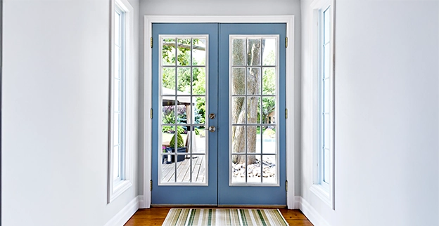 Bright entryway featuring blue double doors with glass panes.