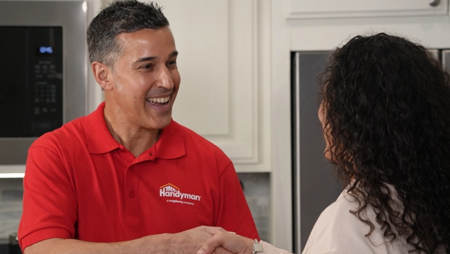Mr. Handyman confidently shaking hands with a valued customer.