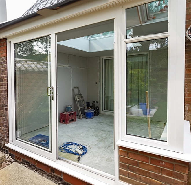 Bright glass doors reveal an unfinished room.