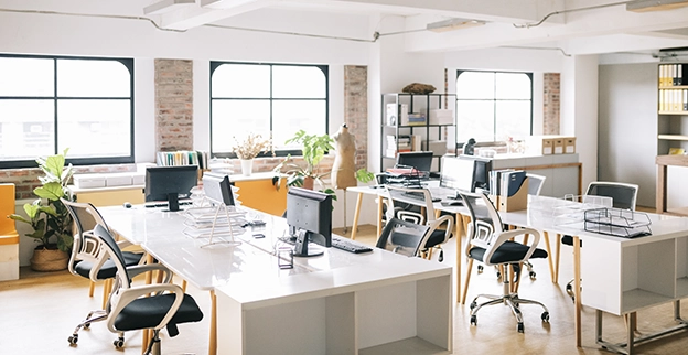 Bright modern office space featuring multiple desks creating a collaborative work environment.