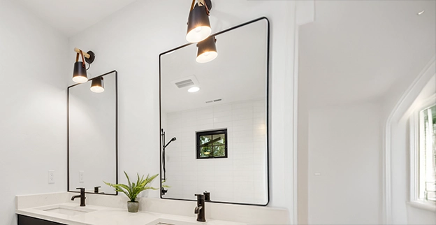 Modern bathroom with dual black-framed mirrors.