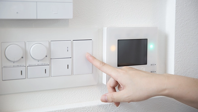 Person using a wall switch.