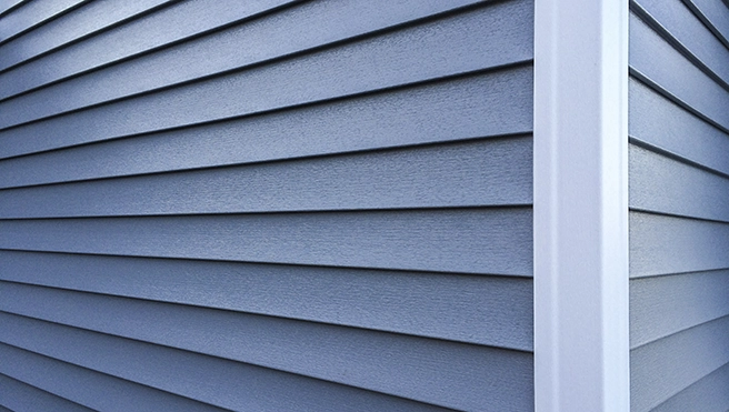 Close-up of a modern gray siding with horizontal grooves, showcasing a sleek design and a white corner trim.