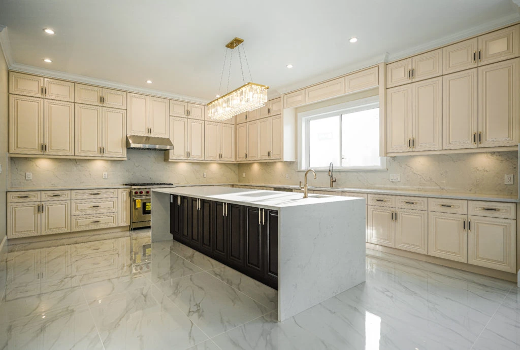 A spacious kitchen featuring elegant marble floors and sleek white cabinets.