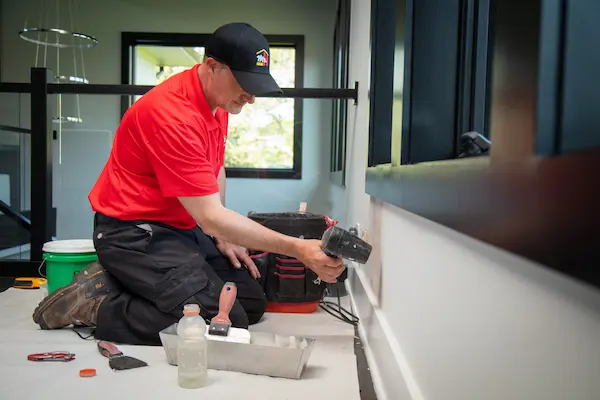 A Mr. Handyman technician repairing drywall.