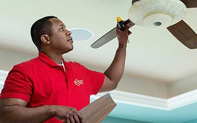 Mr. Handyman tech repairing a ceiling fan