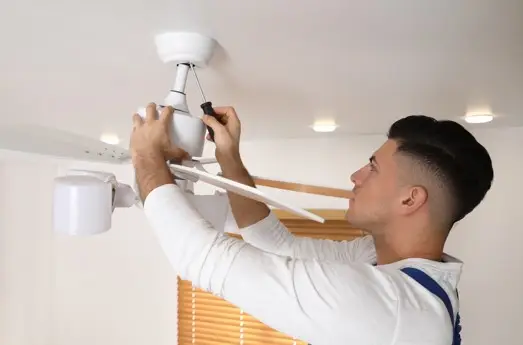 young man installing ceiling fan
