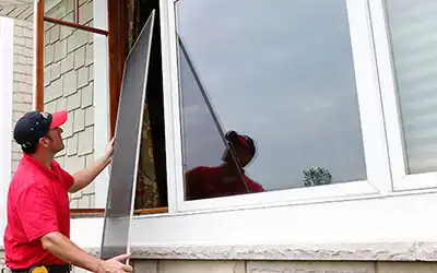 A Mr. Handyman technician installing a window.