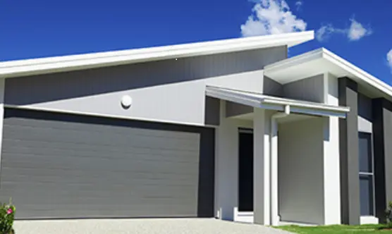 A grey house against a bright blue sky.