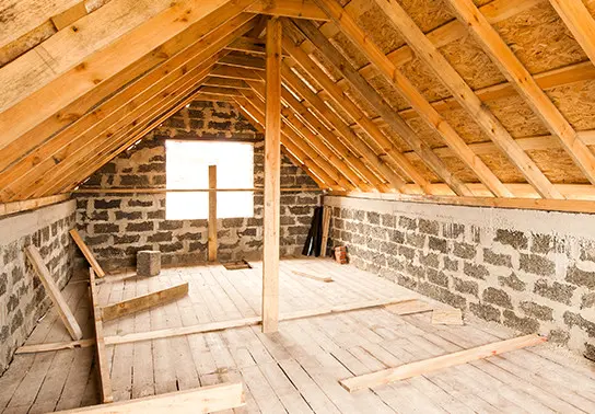 An unfinished attic with exposed wood and bricks.