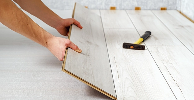 Hands laying down wooden slats.