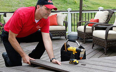 Handyman laying down composite boards on deck.