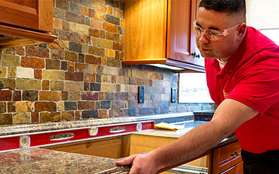 Handyman installing and leveling granite countertop.