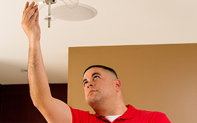 Handyman installing light fixture