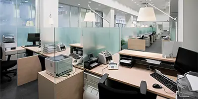 Office space with desks, partitions and computer equipment.