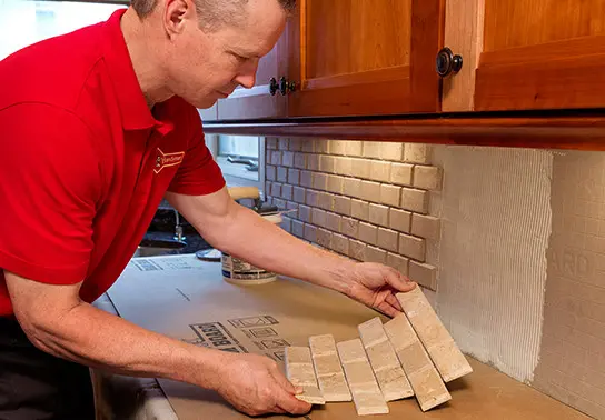 handyman installing subway tile